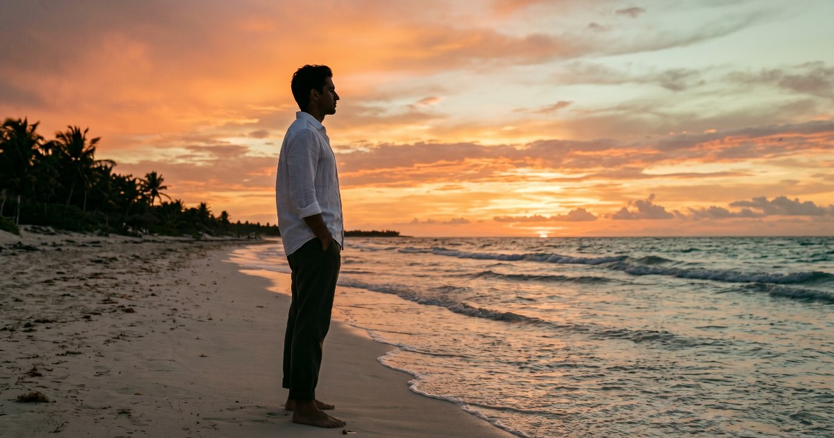 Silueta de figura en atuendo casual de negocios sobre playa desierta de Tulum al atardecer, mirando el horizonte caribeño, pose contemplativa.